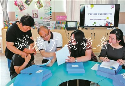 无锡市广新小学校长过秦勇（右三）、副校长朱甄珍（右一）与梁溪区特教指导中心资源教师陈向华（右二），和学生小芮及家长一起商量个别化教育方案。